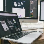 Laptop and external monitors displaying website design and page layout work