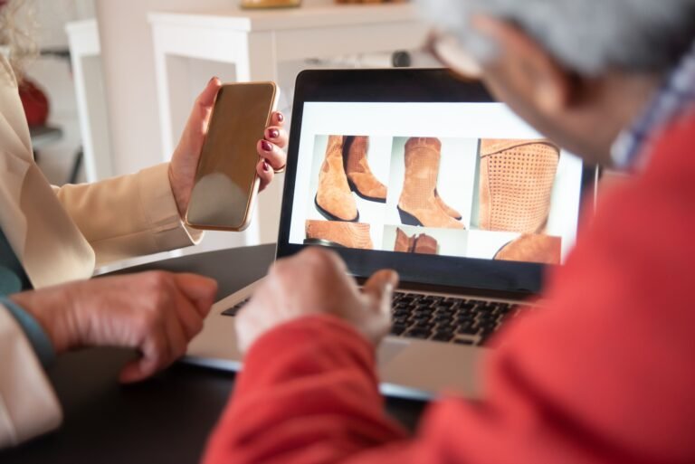 Two people browsing an online store on a laptop and smartphone